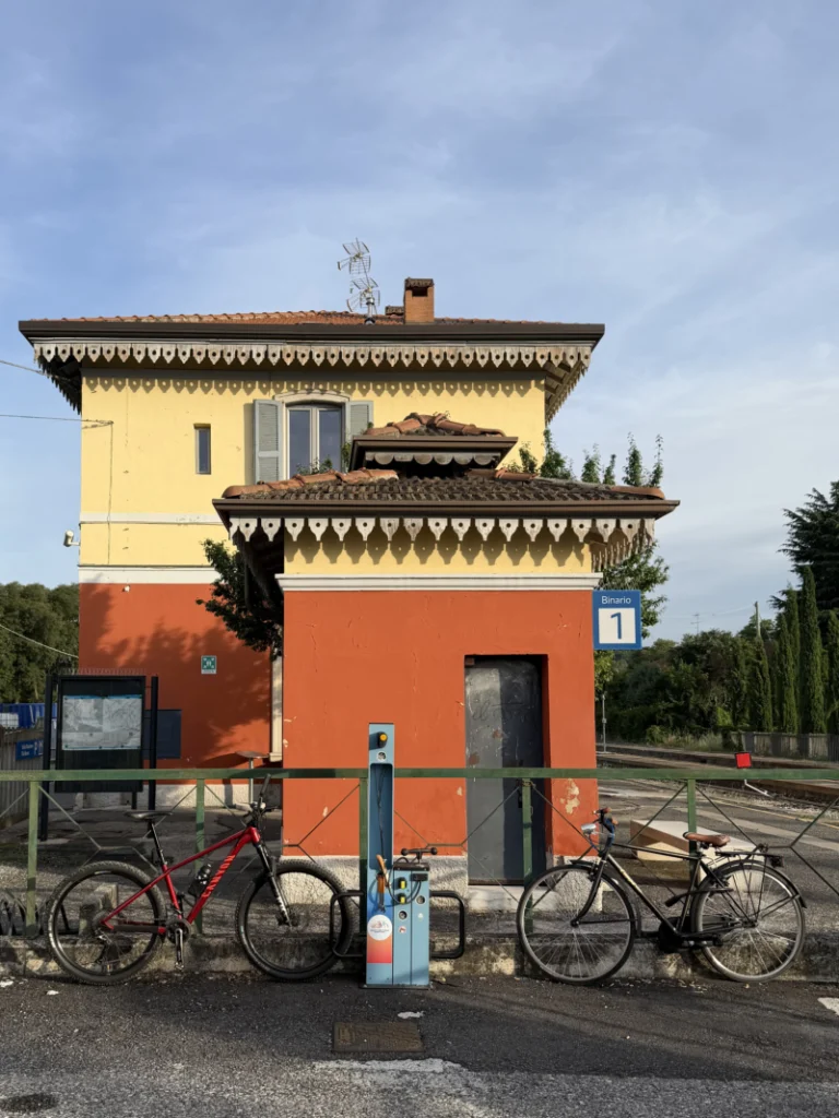 Punto assistenza bici stazione ferroviaria Biciclette parcheggiate vicino a una colonnina di ricarica e riparazione bici al binario 1 di una stazione ferroviaria